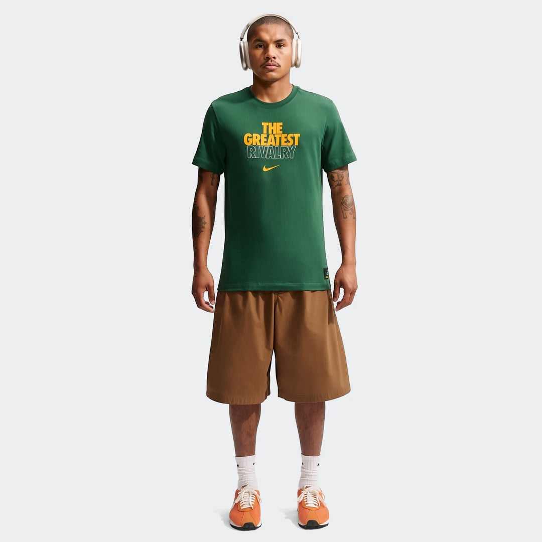 Male model wearing a dark green 2026 Nike Springboks Rugby's Greatest Rivalry Tour Men T-shirt, brown shorts, and orange