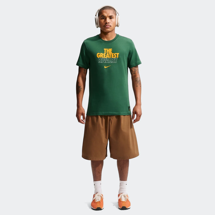 Male model wearing a dark green 2026 Nike Springboks Rugby's Greatest Rivalry Tour Men T-shirt, brown shorts, and orange