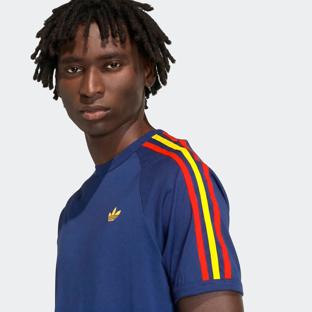 Close-up of a male model wearing a navy blue Adidas 3-Stripes T-Shirt with red and yellow stripes on the sleeves.
