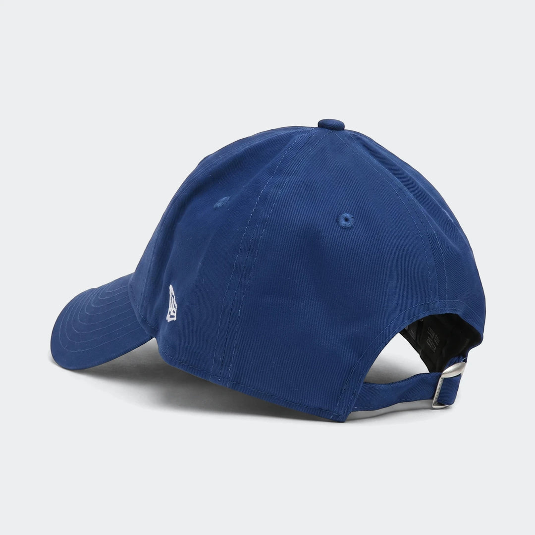 A blue 940 Todd League Ess baseball cap, shown from a rear-left angle, featuring a white embroidered logo and an adjustable