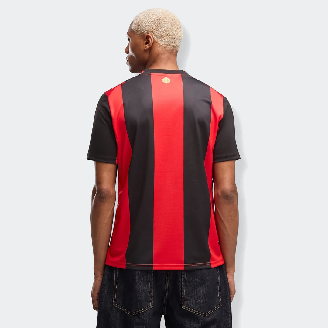 Back view of a male model wearing the Ac Milan 26/27 Home Jersey, featuring black and red vertical stripes.