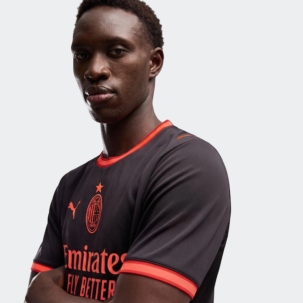 AC Milan 26/27 Third Jersey for men in black with orange accents, worn by a model, showing the front with club crest and