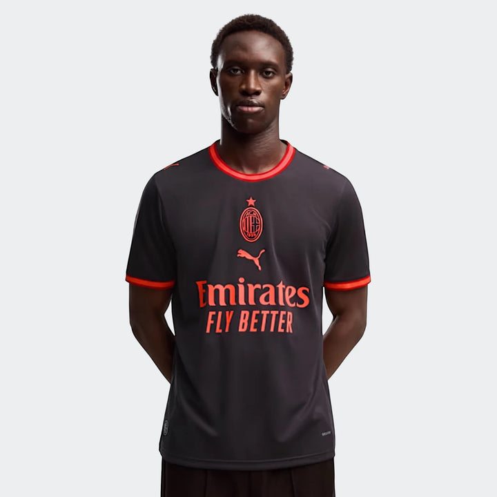 Ac Milan 26/27 Third Jersey for men in dark grey with vibrant red trim and sponsor logos, worn by a male model.