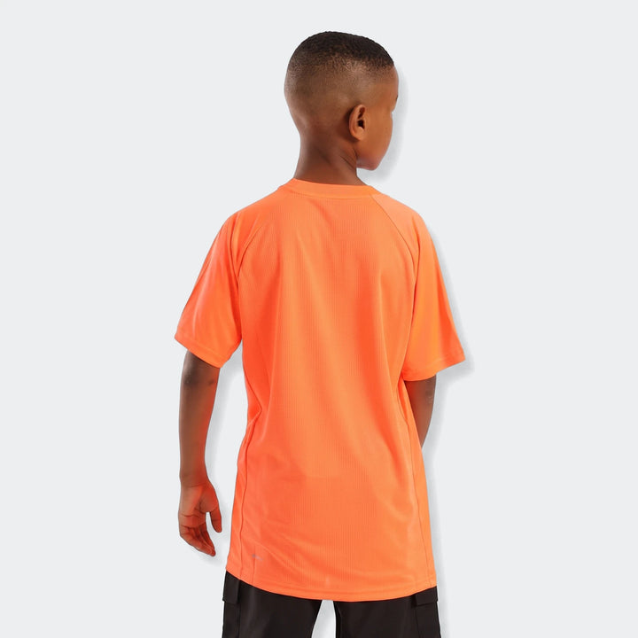 Young boy in an orange active sports graphic tee and black shorts, seen from the back. The tee features a textured fabric.