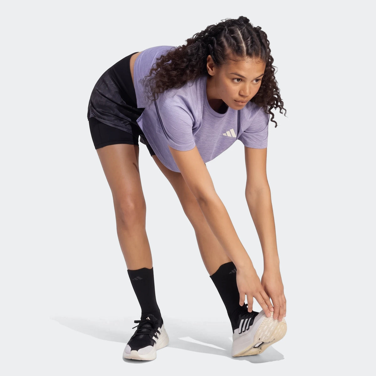 Lavender Adi365 Soft Touch T-Shirt on a woman in black shorts and sneakers, captured in a full-body view.
