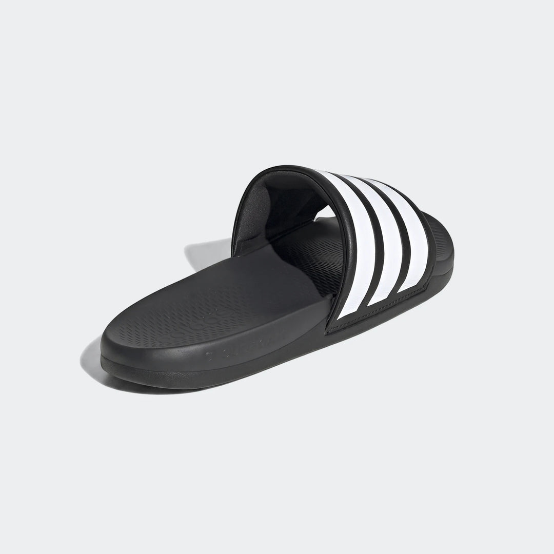 Black Adidas Adilette Comfort 2.0 slides with white three-stripes, shown from a side angle.