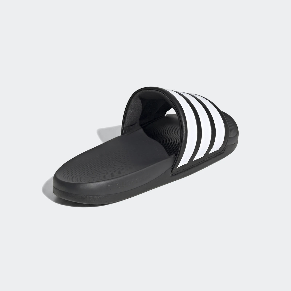 Black Adidas Adilette Comfort 2.0 slides with white three-stripes, shown from a side angle.