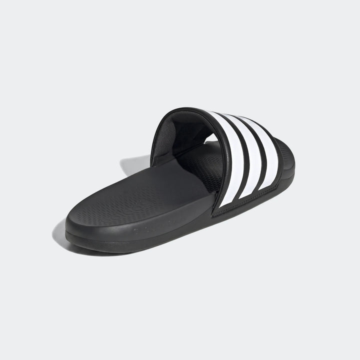 Black Adidas Adilette Comfort 2.0 slides with white three-stripes, shown from a side angle.