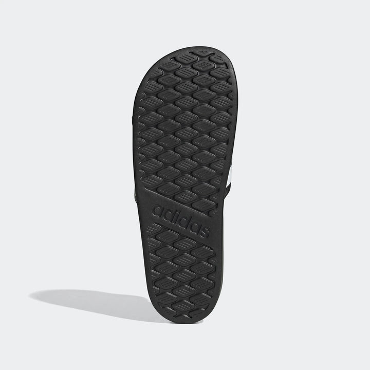 Black Adidas Adilette Comfort 2.0 slides, featuring the textured sole and embossed logo, viewed from above.