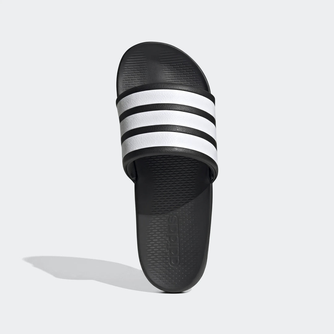 Top-down view of a black Adidas Adilette slide sandal featuring three bold white stripes across the strap. The comfortable