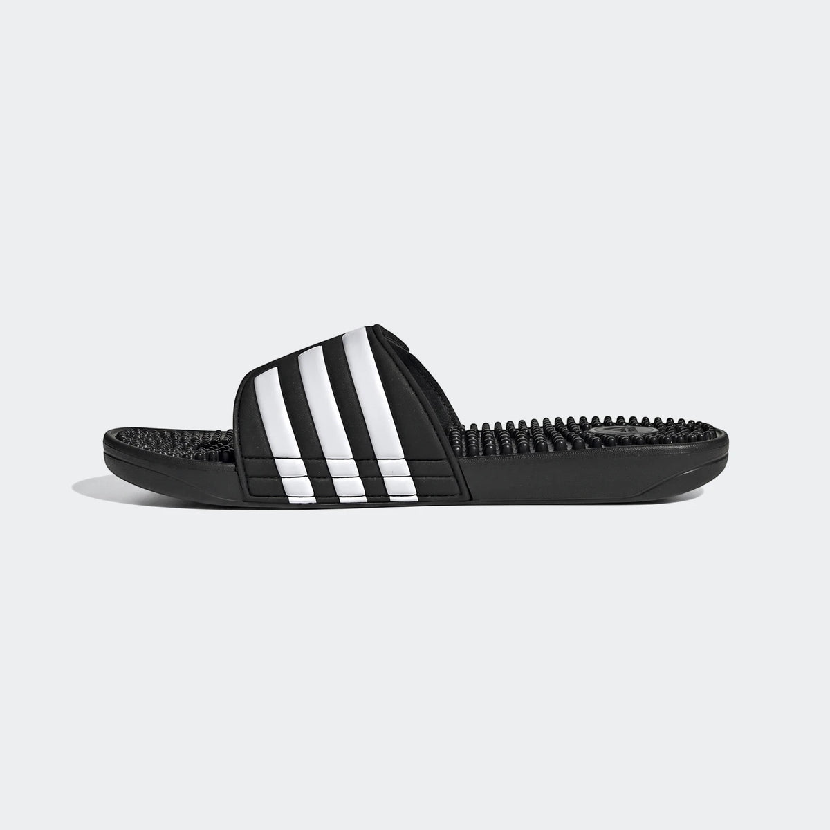 Black Adidas Adissage Slides with white stripes, featuring a textured footbed, presented in a side profile view.