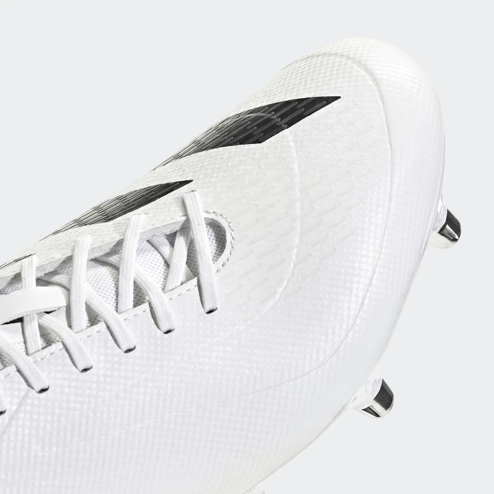 Close-up of a white Adidas Adizero Rs15 Ultimate Sg Rugby Boot, showcasing the textured upper and black Adidas stripes.