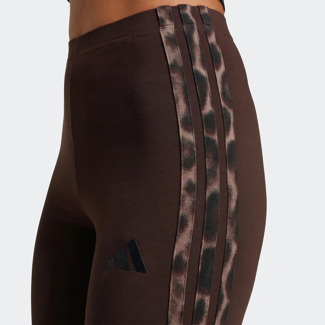 Close-up of brown Adidas All-Over Print Infill Leggings with leopard print three stripes worn on a model.