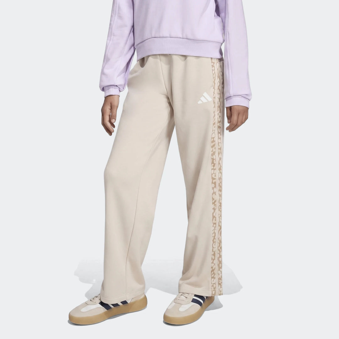 Beige Adidas Angled 3-Stripes French Terry Pants for women, featuring a wide-leg fit and side stripe details, worn by a