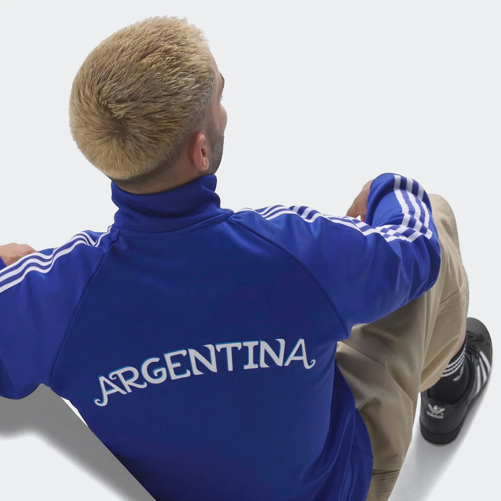 Blue Adidas Argentina Originals Track Top, worn by a person from the back, with white three stripes on sleeves and