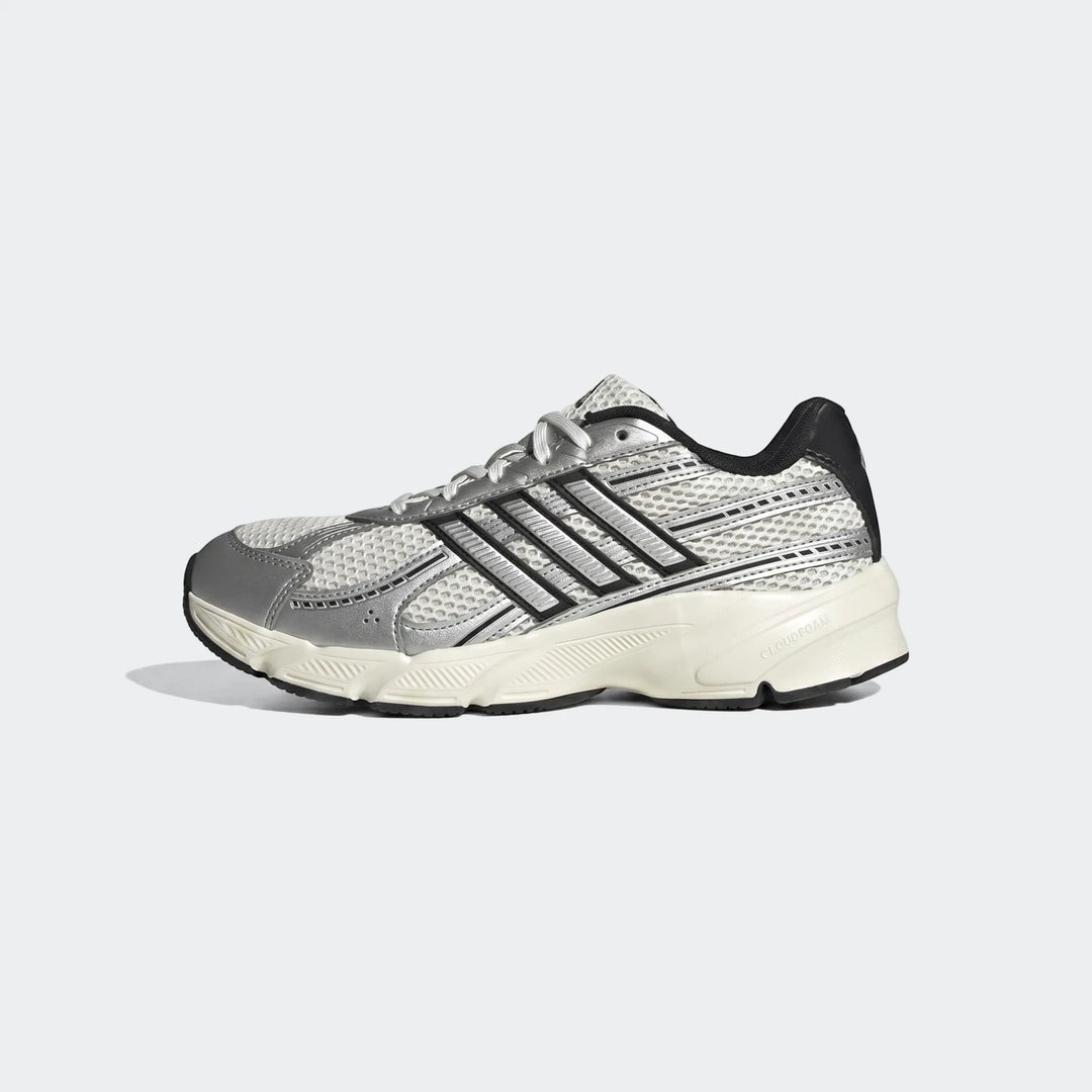 Adidas athletic sneaker featuring white mesh and silver metallic accents, captured in a side profile view.