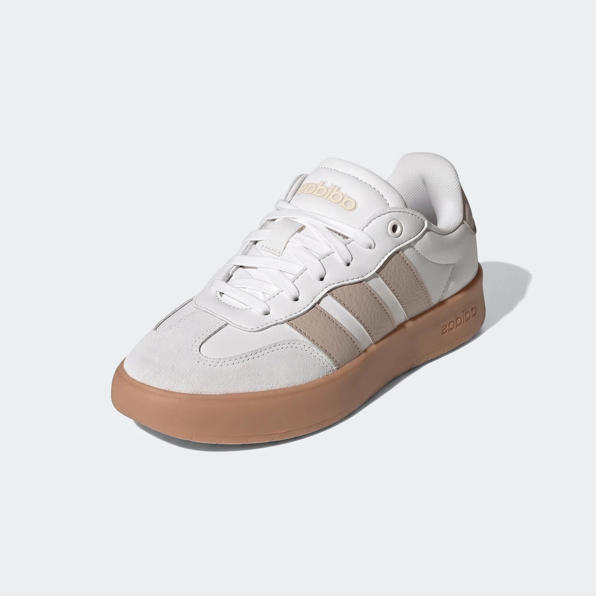 White and beige Adidas Barreda shoes with a gum sole, low-top sneakers in a three-quarter view.