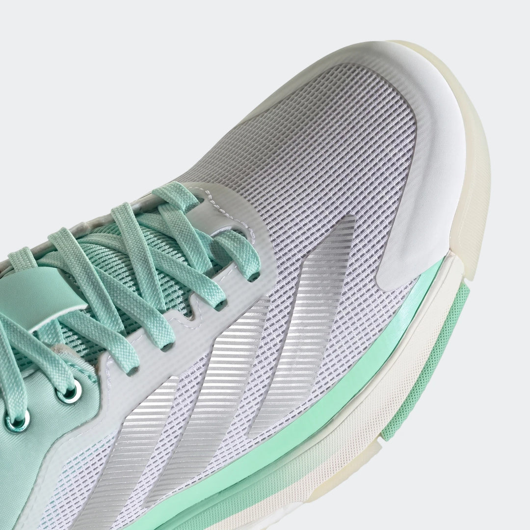 Close-up of a white and mint green Adidas Crazyquick Boost Padel Shoe, showcasing its mesh upper and lacing.