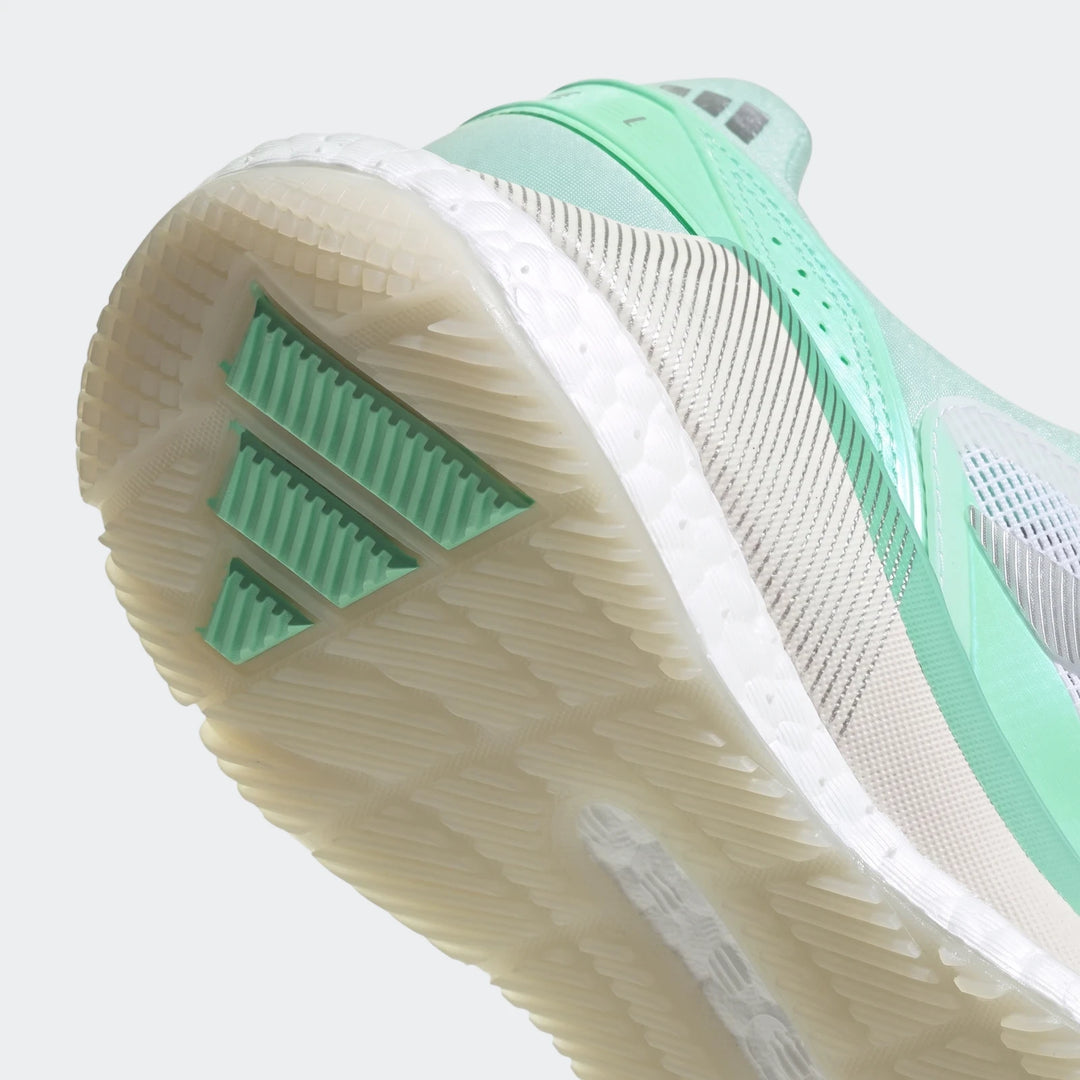 Close-up side view of mint green and off-white adidas Crazyquick Boost Padel Shoes, showcasing the translucent sole and