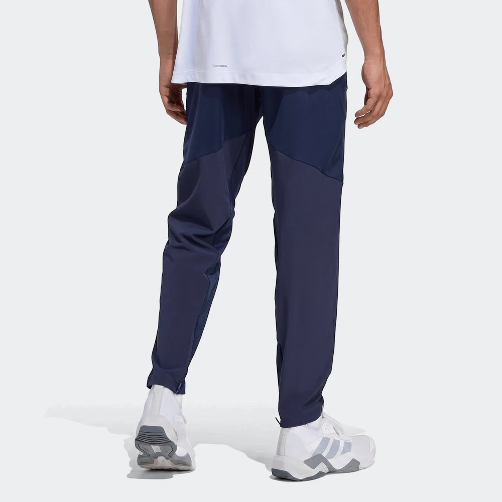 Navy blue Adidas D4T Hybrid Pants for men, worn by a model from the back. These athletic pants feature darker blue panels