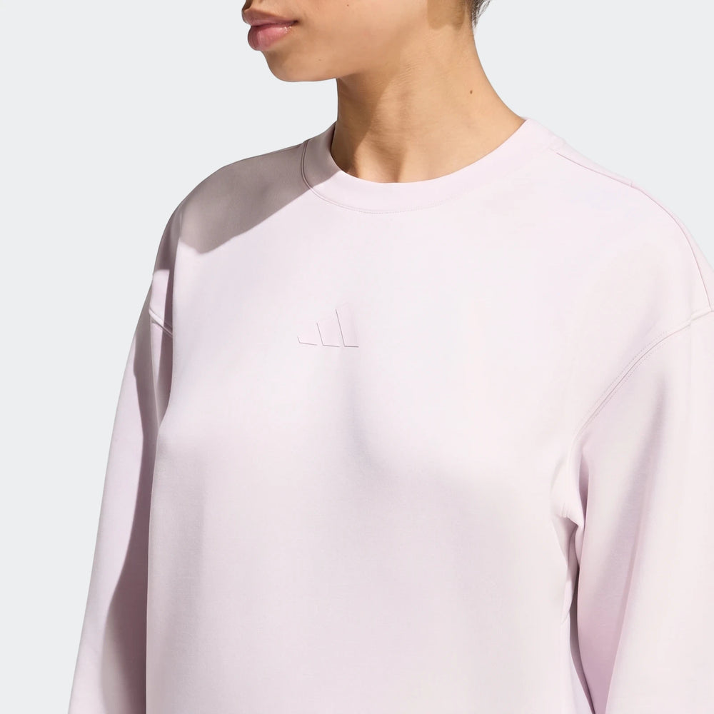 Close-up of a model wearing a light purple Adidas D4T Knit Crew Sweatshirt, showcasing the knit fabric and embossed logo.