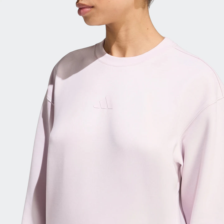 Close-up of a model wearing a light purple Adidas D4T Knit Crew Sweatshirt, showcasing the knit fabric and embossed logo.