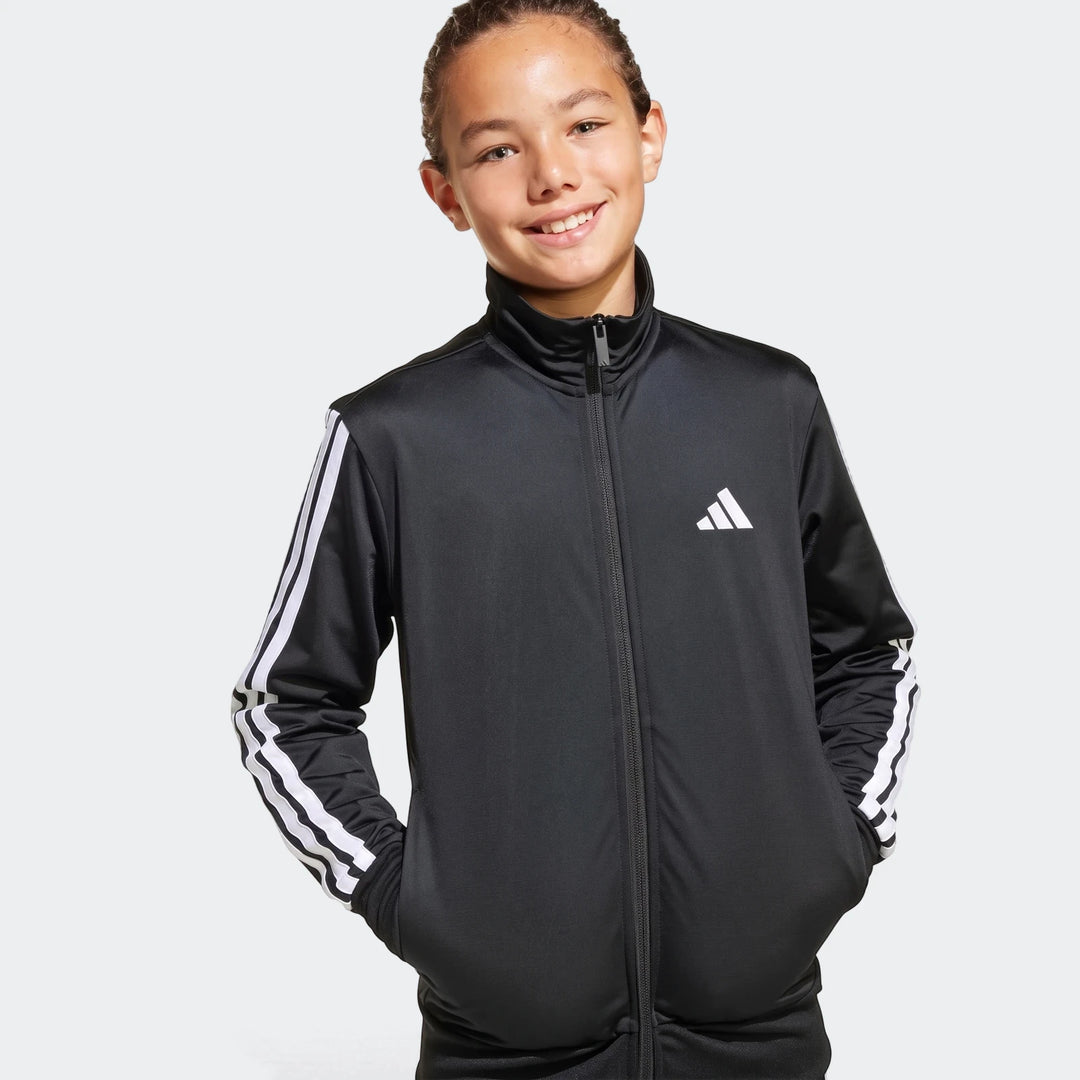 Smiling young person wearing a black Adidas Essentials Climacool track jacket with white three stripes on the sleeves.