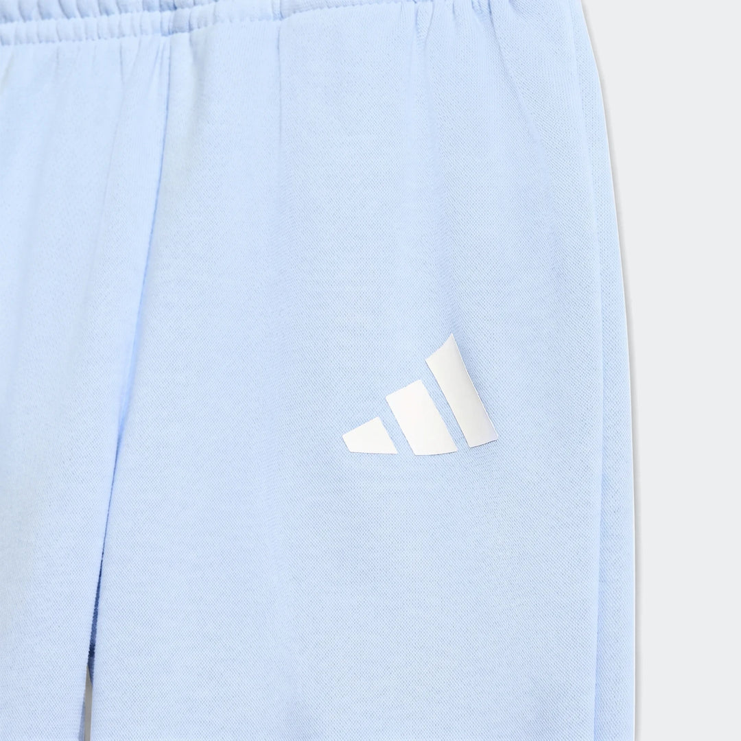 Close-up of a light blue adidas Essentials Jogger Set showing the soft fabric and white logo detail, perfect for comfortable