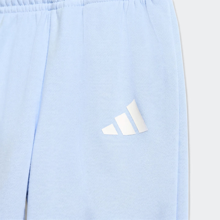 Close-up of a light blue adidas Essentials Jogger Set showing the soft fabric and white logo detail, perfect for comfortable