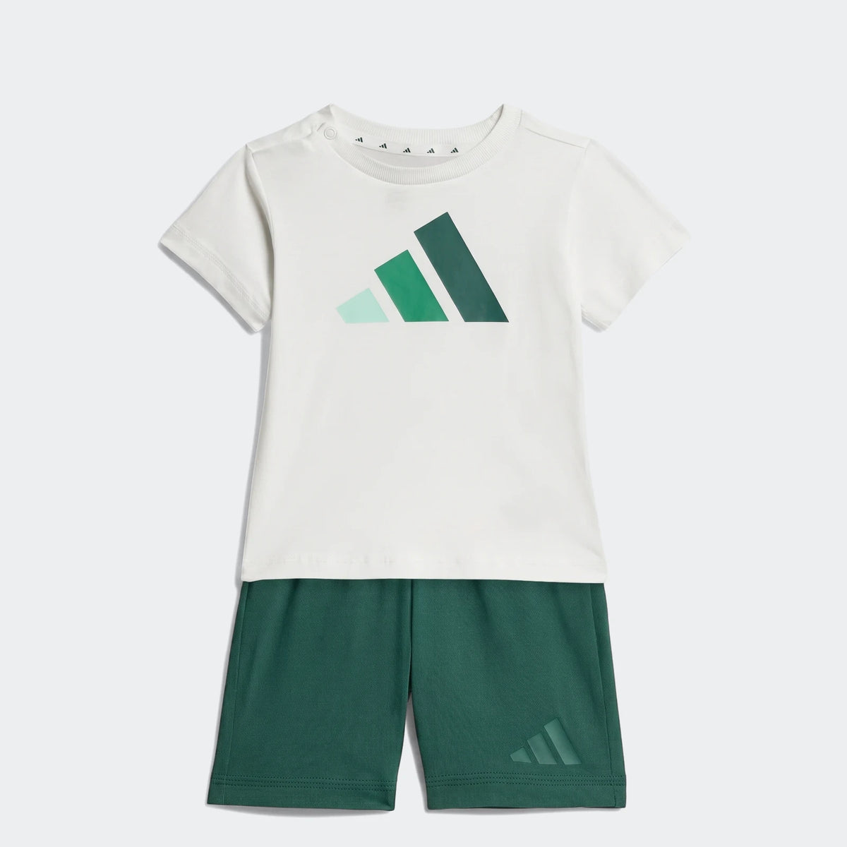 Adidas Essentials Kids' Tee Set: white t-shirt with green logo and dark green shorts, flat-lay view.