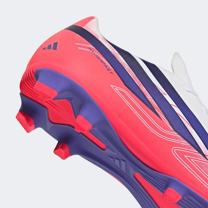 Close-up of a pink, white, and blue Adidas F50 Hyperfast Club kids' firm ground football boot, showing the soleplate and