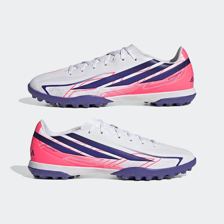 Two white, blue, and pink Adidas F50 Hyperfast Club Turf Football Shoes are displayed from a side view, highlighting the