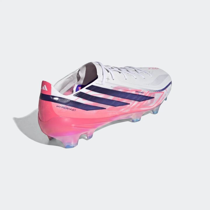 Adidas F50 Hyperfast Elite Firm Ground Football Boots in white, pink, and navy, featuring a unique stud configuration.