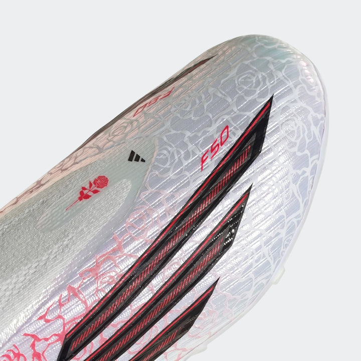 Close-up front view of white Adidas F50 League Lamine Yamal kids football boots with red rose pattern and black stripes.