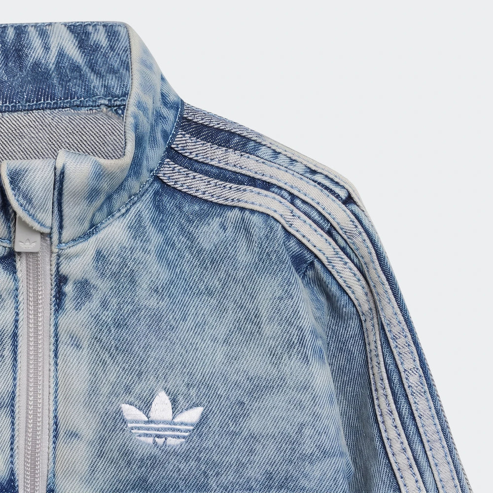 Close-up of an acid wash blue Adidas Firebird Denim Track Top, showing the white embroidered trefoil logo and zipper details.