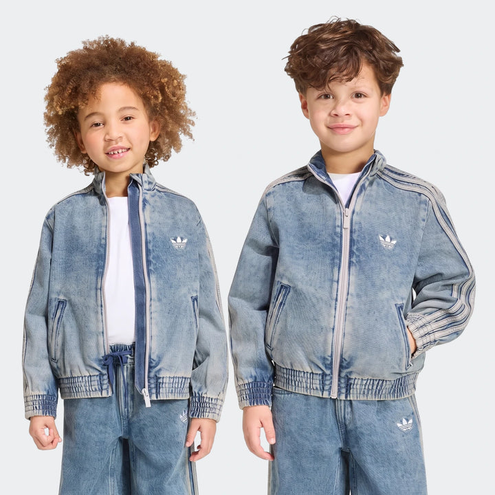 Two young children model Adidas Firebird Loose Denim Track Tops and pants in a light wash denim finish.