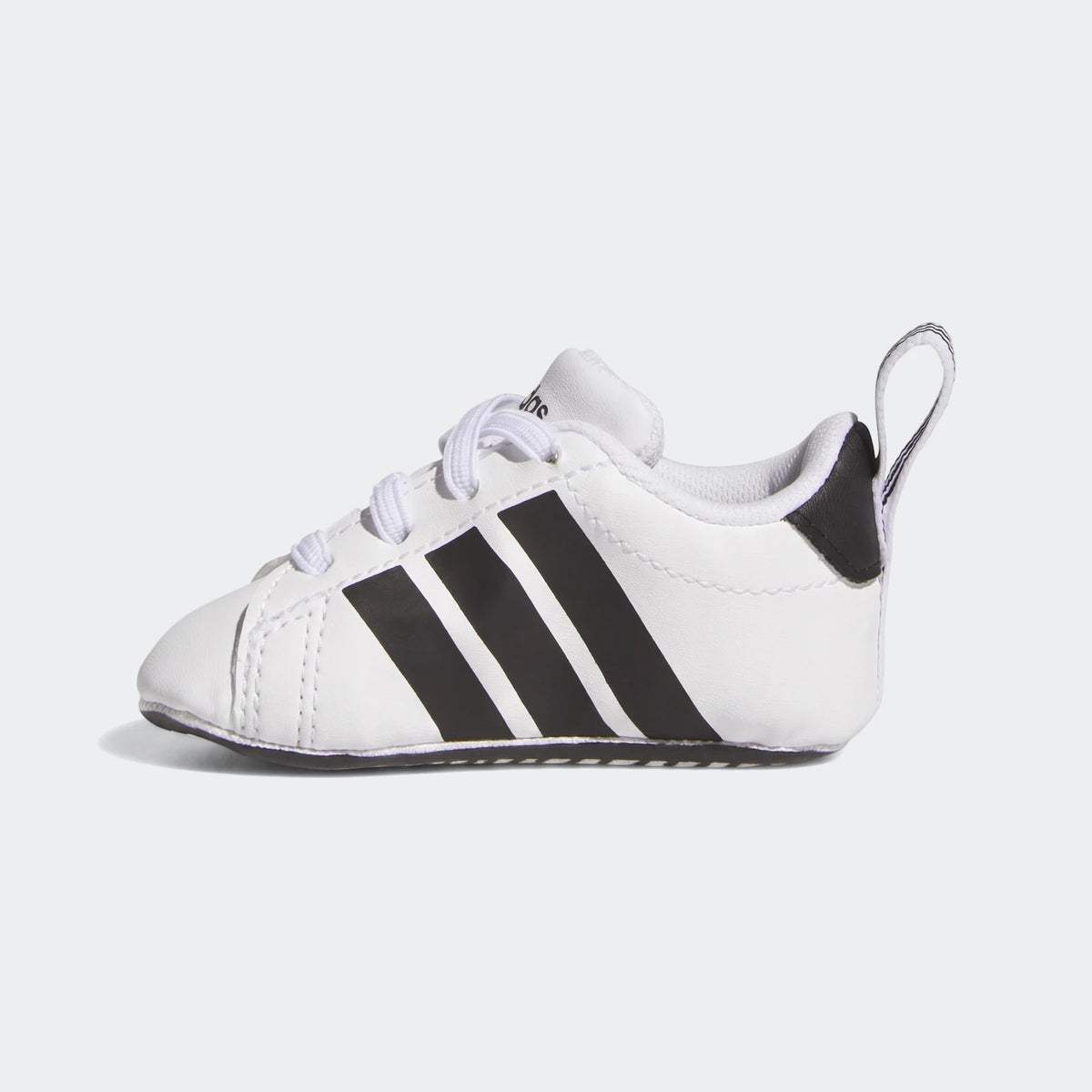 White Adidas Grand Court Crib baby shoe with three black stripes and white laces, shown in a side profile.