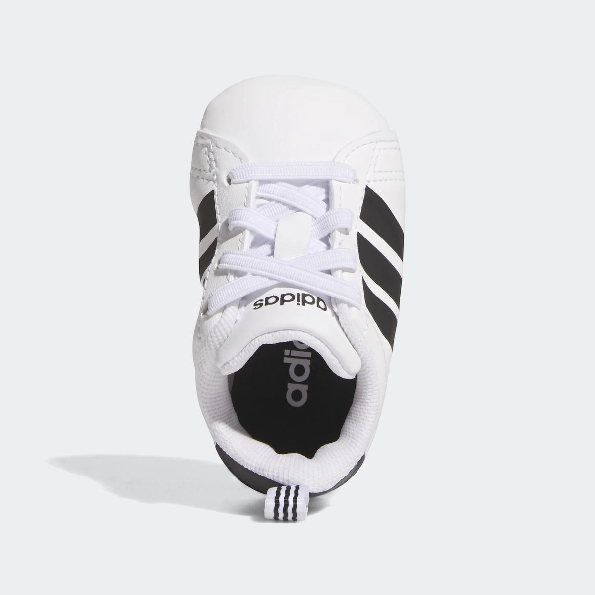 White and black Adidas Grand Court Crib baby shoes, shown from a top-down view, with classic three stripes design.