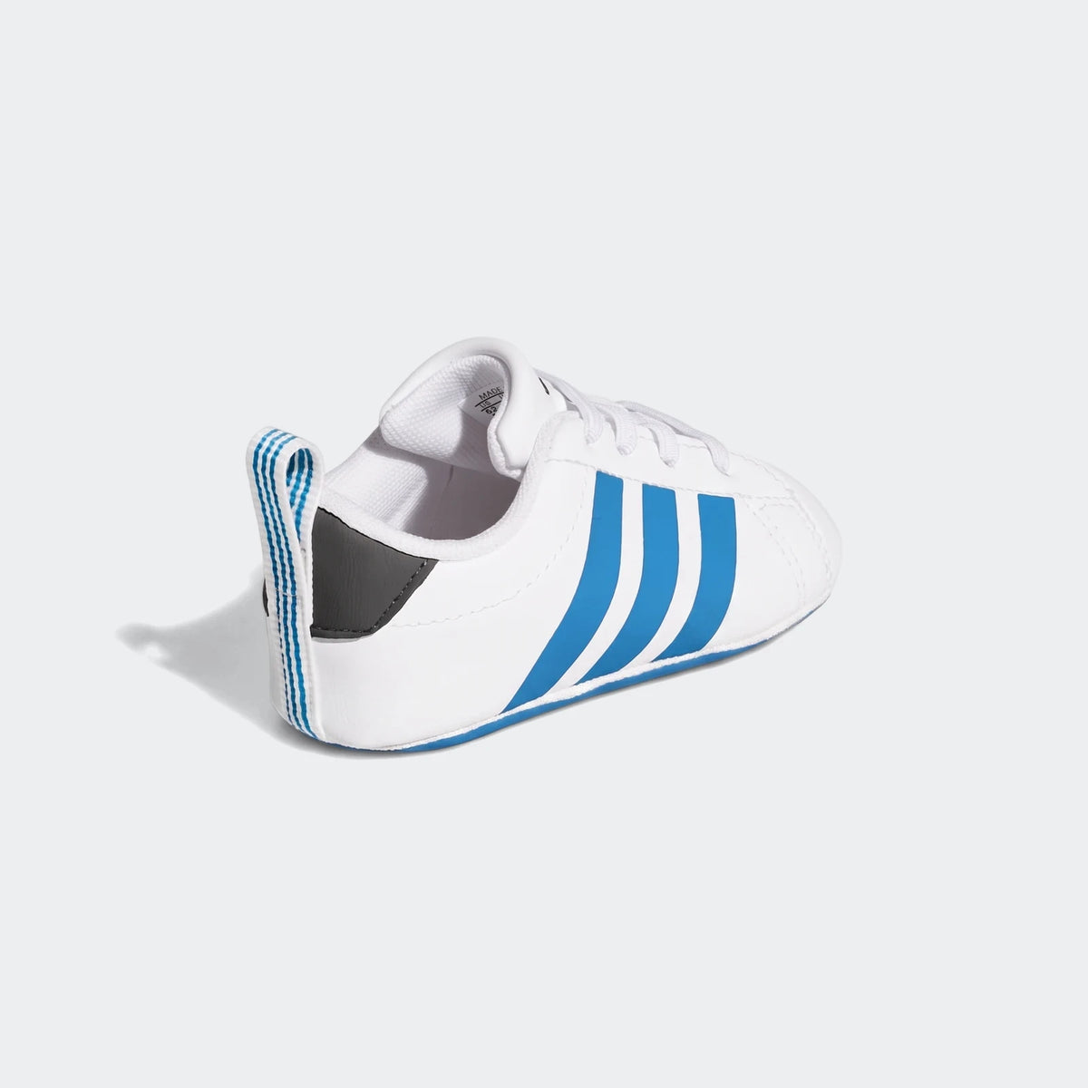 White Adidas Grand Court Crib baby shoes with three blue stripes and blue accents, viewed from a slightly angled side.