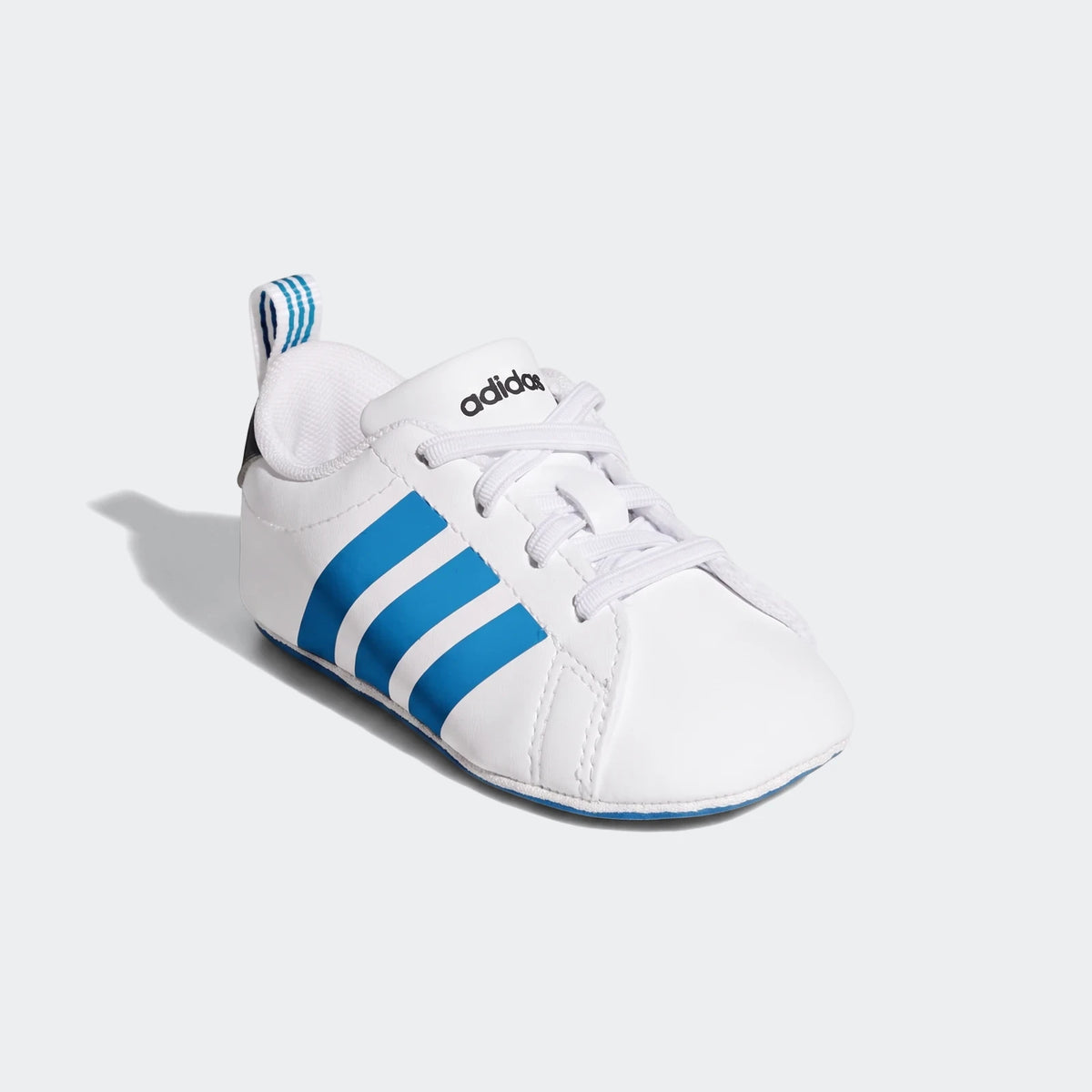 White Adidas Grand Court Crib baby shoes with signature blue three stripes on the side, displayed in a casual product shot.