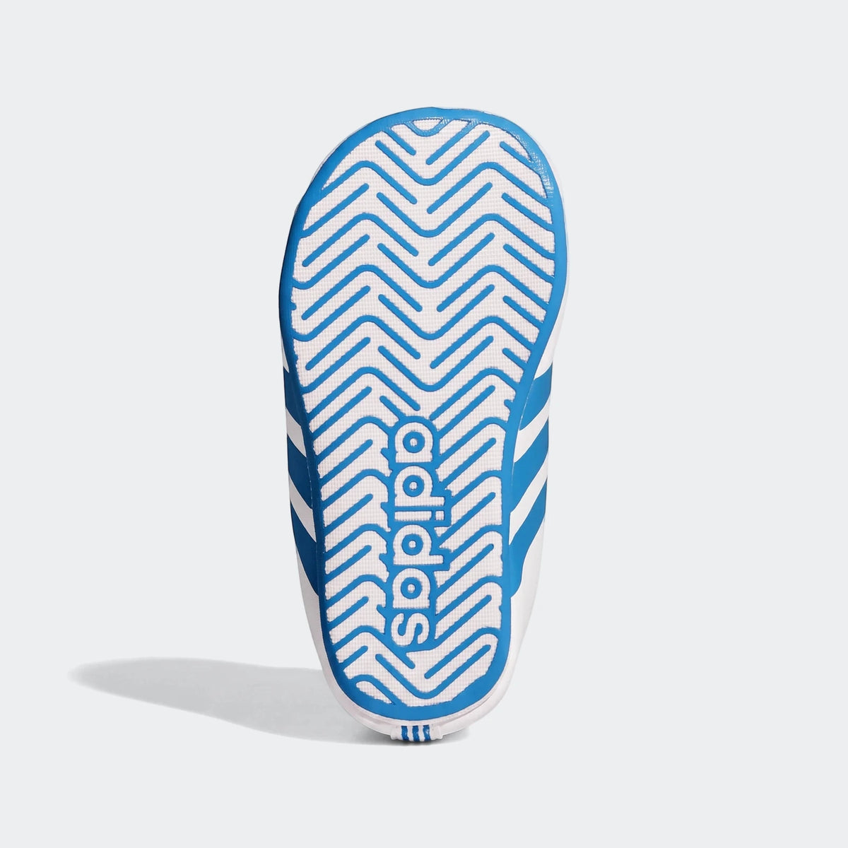 Bottom view of a white and blue Adidas Grand Court Crib shoe, showing the blue sole with zigzag pattern and Adidas logo.