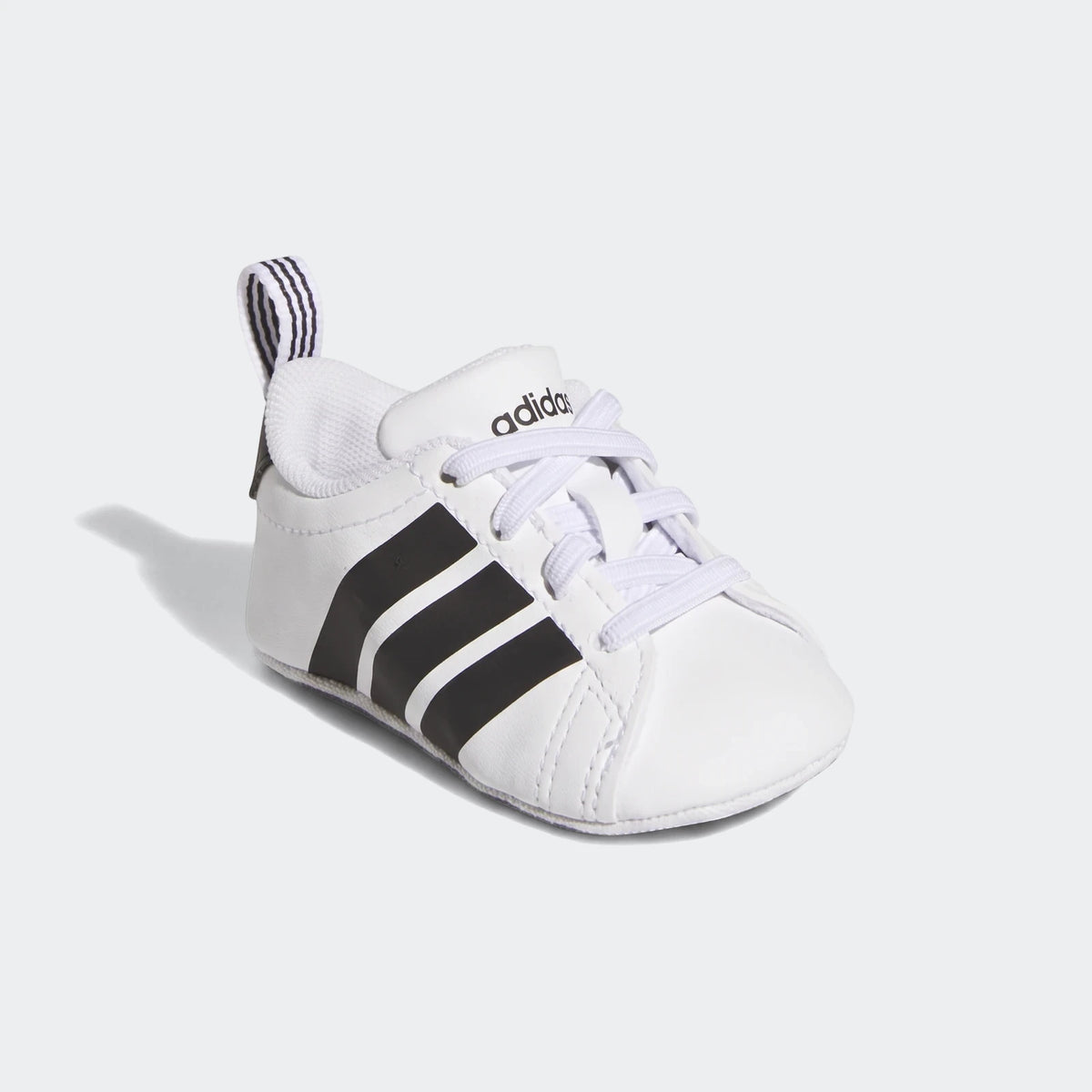 Adidas Grand Court Crib Shoes in white with black stripes, featuring white laces and a striped heel pull tab. Side view of
