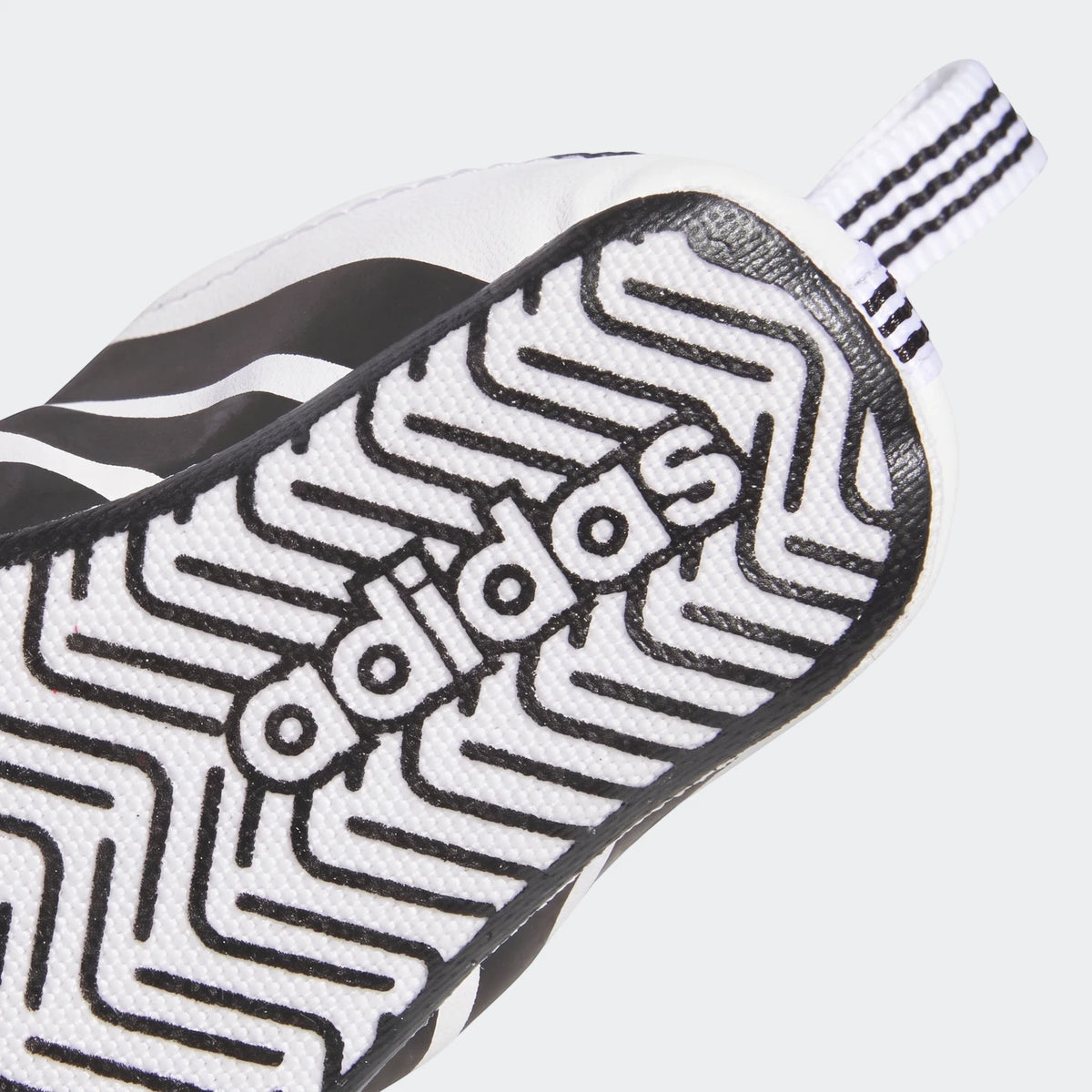 Close-up of the black and white sole of an Adidas Grand Court Shoes Crib, featuring the Adidas logo and a distinctive zigzag