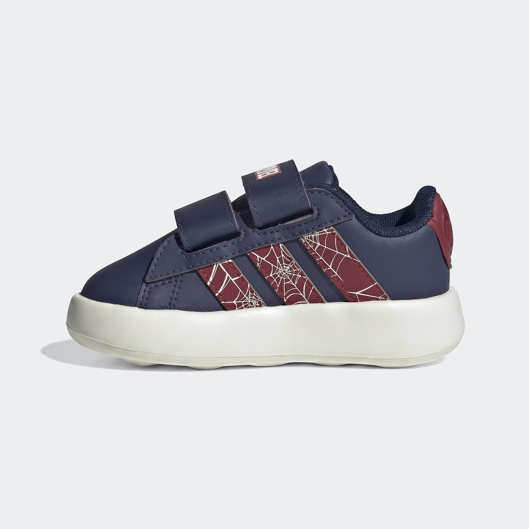 Side view of navy blue and red Adidas Grand Court Spider-Man Cloudfoam Kids shoes with velcro straps and white web patterns.