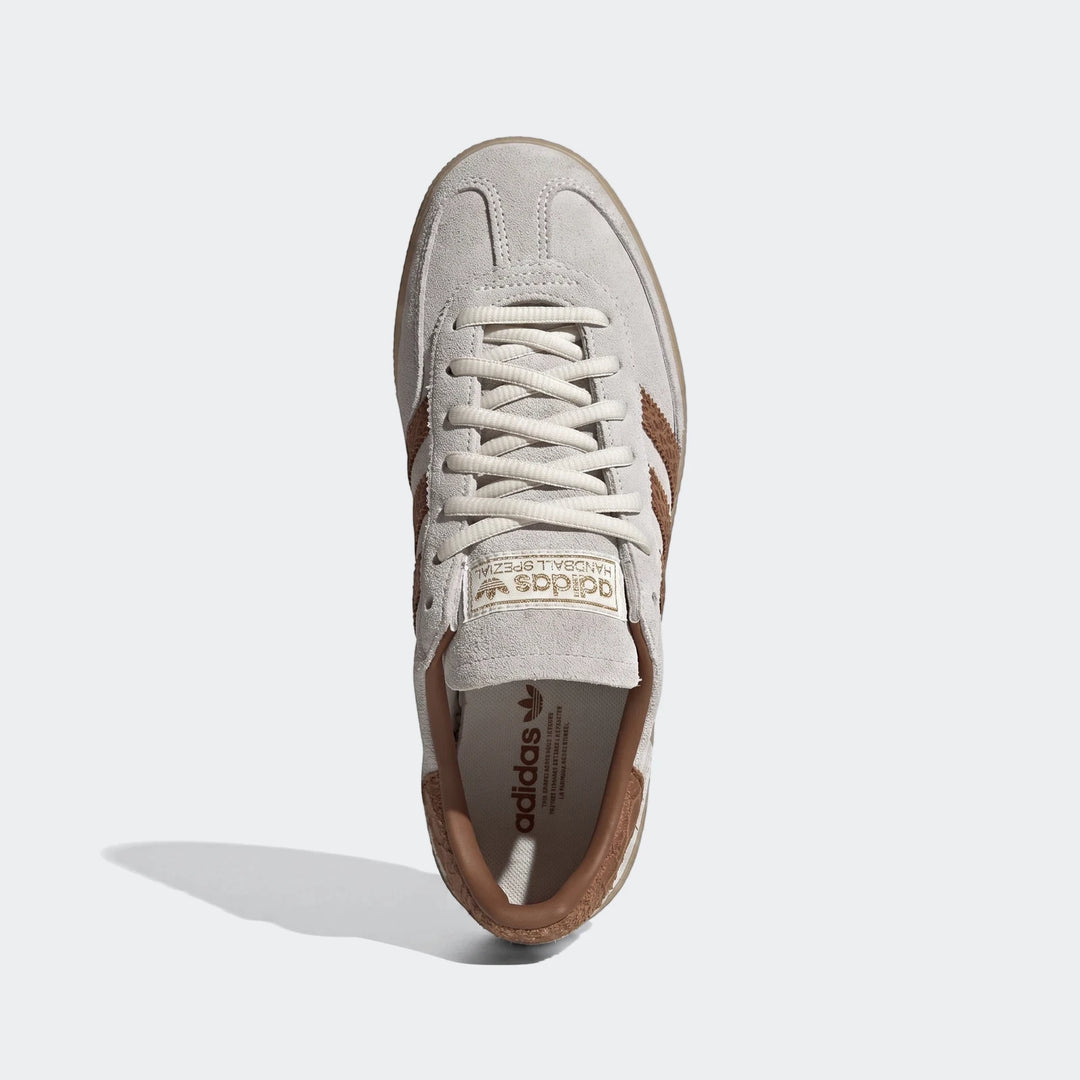 Creamy white Adidas Handball Spezial shoes with brown stripes and gum sole, top-down view. Classic low-profile sneaker.