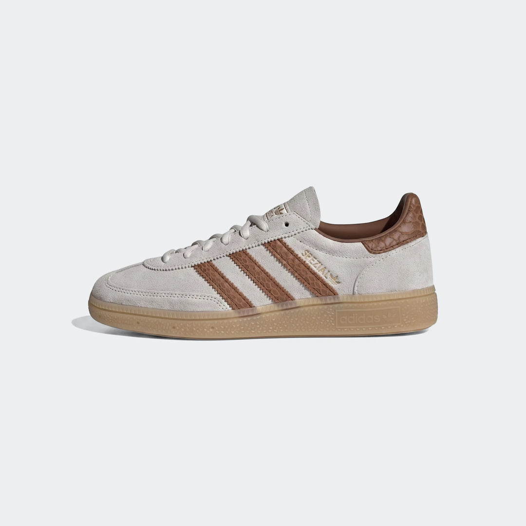 Adidas Handball Spezial shoes in light grey suede with brown stripes and gum sole, viewed from the side.