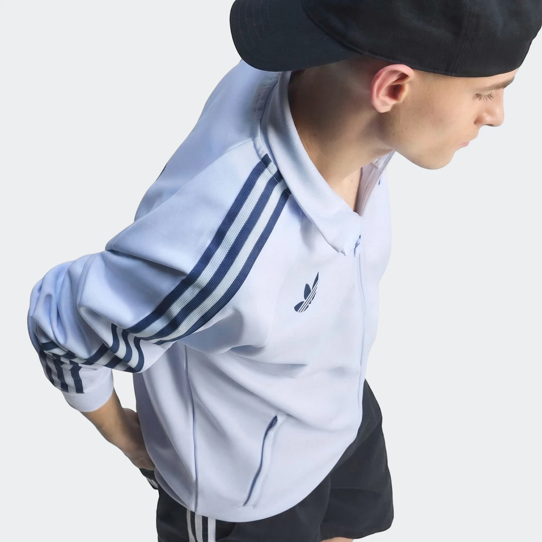 Young man wearing a light blue Adidas Italy Originals Track Top with signature three stripes and trefoil logo, captured from