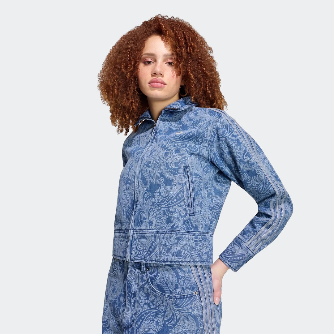 Woman in an Adidas Liberty London Firebird Denim Tracktop and matching pants featuring a distinctive blue paisley print.