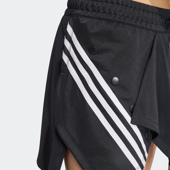 Close-up of a black Adidas X Mia Marquez mini skirt with iconic white three stripes and black snap buttons, showing texture.
