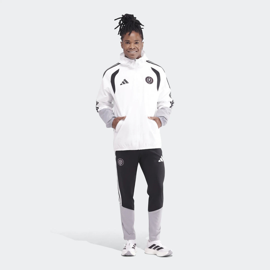 Men's white, black, and grey Adidas Op Tiro26C All Weather Jacket and matching track pants on a model, full body.